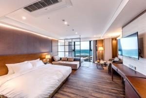 a hotel room with a large bed and a television at Dyne Oceano Hotel in Jeju