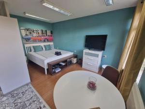 a living room with a white table and a tv at La Maison Ruse Apartments in Ruse