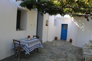 un tavolo e sedie in un cortile con porta blu di EVANTHIA S HOUSE a Katákoilos