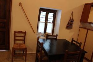 a dining room with a table and chairs and a window at EVANTHIA S HOUSE in Katákoilos +16 photos