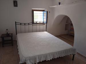 una camera con un letto in una stanza con una finestra di EVANTHIA S HOUSE a Katákoilos