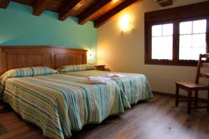 um quarto com uma cama, uma cadeira e uma janela em Casa Rural Sarobetxea en Larrayoz, Navarra 