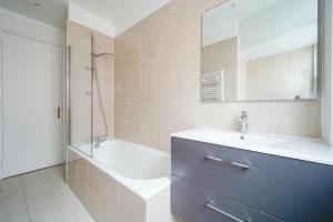 y baño con lavabo, ducha y bañera. en Apartment next to Palais des Congrès - Neuilly, en Neuilly-sur-Seine