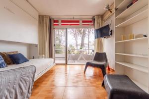 ein Schlafzimmer mit einem Bett und einem Stuhl und einem Fenster in der Unterkunft Luminoso Bungalow con parking in Tarragona
