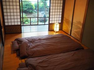 fumoku - Vacation STAY 04226v في تشينو: سرير في غرفة بها مصباح ونوافذ