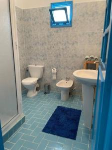 ein Bad mit einem Waschbecken, einem WC und einem Fenster in der Unterkunft Superbe maison à M'diq in Mʼdik