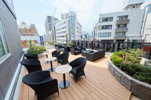 einen Balkon mit Tischen und Stühlen auf einem Gebäude in der Unterkunft Rembrandt Style Honatsugi in Atsugi