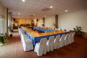 einen langen Tisch in einem Zimmer mit weißen Stühlen in der Unterkunft Dhulikhel Lodge Resort in Dhulikhel