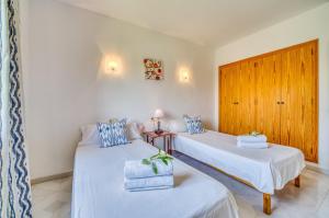 サ・コマにあるRosas 28のベッド2台と木製のドアが備わる客室です。