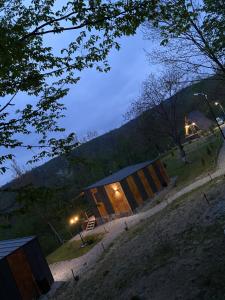 une maison avec un extérieur en bois la nuit dans l'établissement Casutele din Poienita, à Comarnic