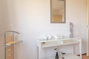 a white table with a mirror on a wall at Duinerei Groote Keeten in Callantsoog +93 photos