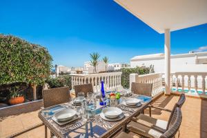 a table and chairs on a patio with a view of the ocean at Villa Tian in Puerto Calero