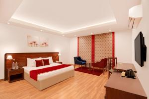 マナリにあるLemon Tree Hotel Manaliのベッドとデスクが備わるホテルルームです。