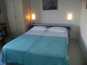 Cama azul en habitación con 2 almohadas en Blu Mare, en Ponza