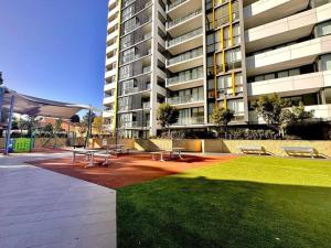 a group of picnic tables and benches in front of a building at Cosy One Bedroom Apartment in Castle Hill, NSW in Castle Hill
