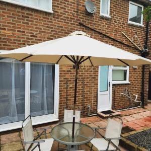 a table with an umbrella in front of a brick building at Sunny South Shields House in Jarrow