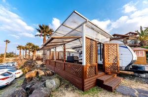 a tiny house with a wrap around deck at Dyne Resort in Jeju