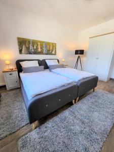 a bedroom with a large bed with blue sheets and a rug at Art-Appartement in Bielefeld