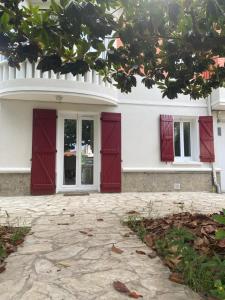 uma casa branca com portas vermelhas e um pátio em Sweet Home - 55m2 appt, garden, swimming pool, parking em Toulouse