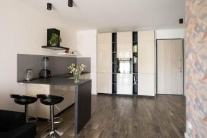 a kitchen with a counter and stools in a room at Letnica living space apartment in Gdańsk
