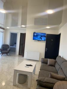 ein Wohnzimmer mit einem Sofa und einem Tisch in der Unterkunft Guest House OASI in Batumi