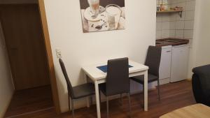 a small kitchen with a white table and chairs at Bertel 1 in Wernigerode +8 photos