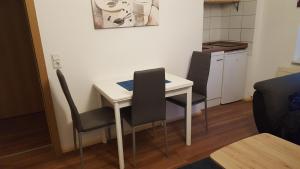 a small kitchen with a white table and chairs at Bertel 1 in Wernigerode