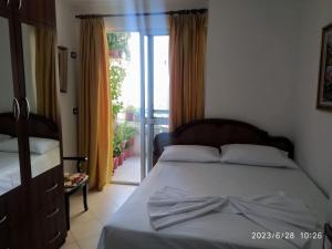 - une chambre avec un lit et une porte donnant sur un balcon dans l'établissement Holiday apartment Shengjin, à Shëngjin