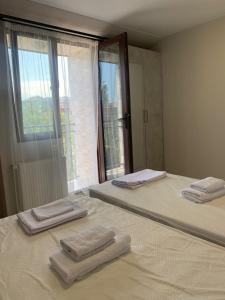 2 Betten in einem Zimmer mit Handtüchern darauf in der Unterkunft Guest House OASI in Batumi
