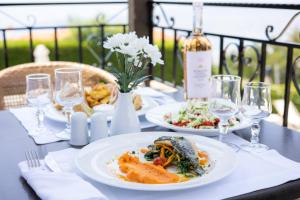 a table with two plates of food and wine glasses at Portaria Hotel in Portariá