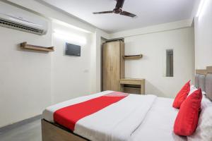 - une chambre avec un lit et des oreillers rouges dans l'établissement OYO Flagship 77674 Hotel White Inn, à New Delhi