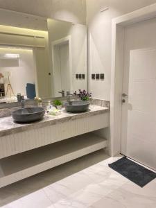 جناح فندقي في فله خاصة في أبها: مغسلتين في حمام مع مرآة كبيرة