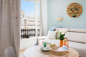 ein Wohnzimmer mit einem Tisch, einem Sofa und einem Fenster in der Unterkunft Centre studio plage et festival in Cannes