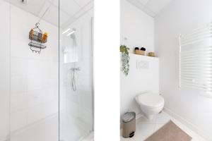 uma casa de banho branca com um chuveiro e um WC. em Centre studio plage et festival em Cannes