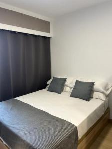 una camera da letto con un grande letto con cuscini blu di Entremares estudio a 150 metros playa a Roquetas de Mar