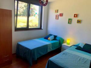 里貝拉的住宿－Los Robles-PLAYA COROSO，一间卧室设有两张床和窗户。