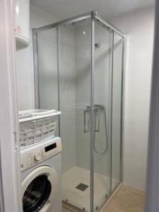 a washing machine and a glass shower in a bathroom at Entremares estudio a 150 metros playa in Roquetas de Mar
