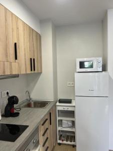 uma cozinha com um frigorífico branco e um micro-ondas em Entremares estudio a 150 metros playa em Roquetas de Mar