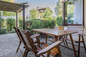 una mesa de madera y sillas en un patio en Ferienwohnpark Immenstaad am Bodensee Zwei-Zimmer-Apartment 53 01, en Immenstaad am Bodensee