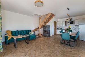 a living room with a green couch and a kitchen at Domki Pieniny in Grywałd