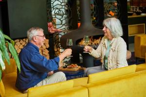 a man and a woman holding glasses of wine at Hotel Kontakt der Kontinenten in Soesterberg