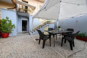 een patio met een tafel en stoelen en een parasol bij Spacious Apartment with Patio in Kalamata
