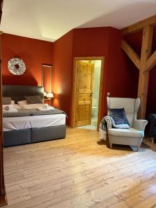 a bedroom with red walls and a bed and a chair at Hotel Henriettenhof Weimarer Land, Weimar-Bad Berka in Bad Berka