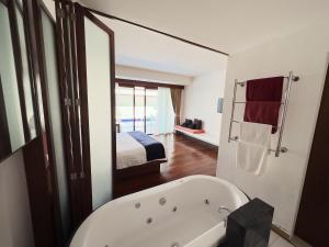 uma casa de banho com banheira e um quarto em Samui Mekkala Resort em Praia de Choeng Mon