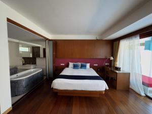 a bedroom with a bed and a tub and a sink at Samui Mekkala Resort in Choeng Mon Beach