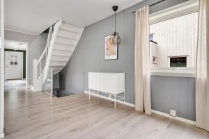 a hallway with a white staircase in a house at Mosjøen Apartments Sentrum in Mosjøen