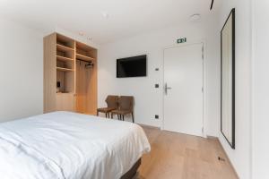 Hof Ter Molen - Luxe kamer met privé badkamer في ديكسميود: غرفة نوم بيضاء مع سرير وتلفزيون