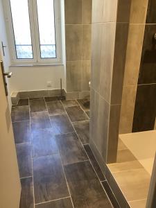 a bathroom with a shower and a tiled floor at Magnifique T4 avec terrasse à Saint-Nectaire - 8 pers in Saint-Nectaire