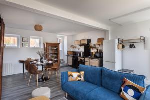 un soggiorno con divano blu e una cucina di La Maison de Louise - Superbe maison avec patio a Cancale