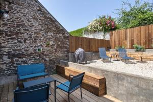a patio with chairs and tables and a fence at La Maison de Louise - Superbe maison avec patio in Cancale